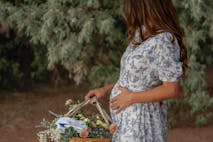 Photo courtesy of Savannah Evans woman in dress holding baby bump