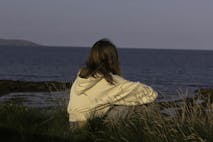 A teenager looking out to sea
