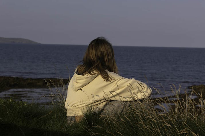 A teenager looking out to sea