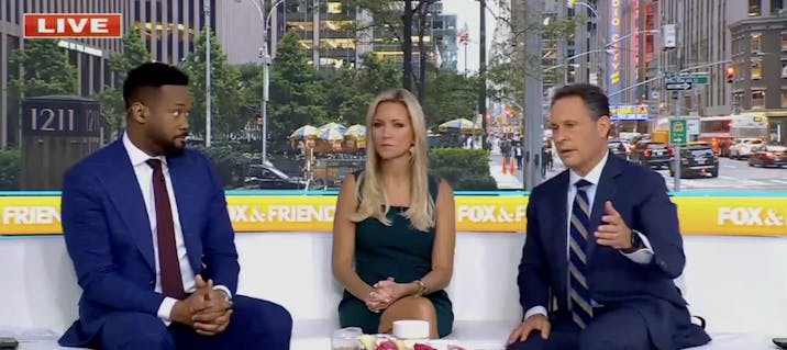 Three anchors for Fox & Friends sitting in a news studio.