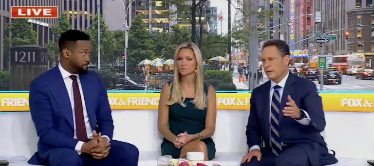 Three anchors for Fox & Friends sitting in a news studio.