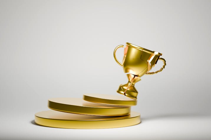 Image: Getty Images Broken trophy toppling over, Digitally Generated Image , 3D rendered