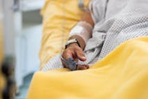 Close-up of a male patient's hand in a hospital bed with oximeter. Senior man admitted hospital.