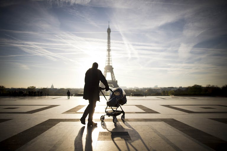 LIONEL BONAVENTURE/AFP via Getty Images A person walks with baby-buggy in front of the Eiffel tower on November 11, 2013 at the Trocadero in Paris.