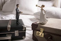 Photo: David Cleveland/Getty Images Wedding figurines on separate suitcases