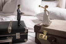 Wedding figurines on separate suitcases