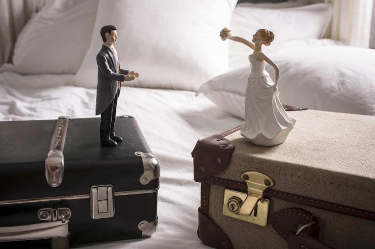 Wedding figurines on separate suitcases