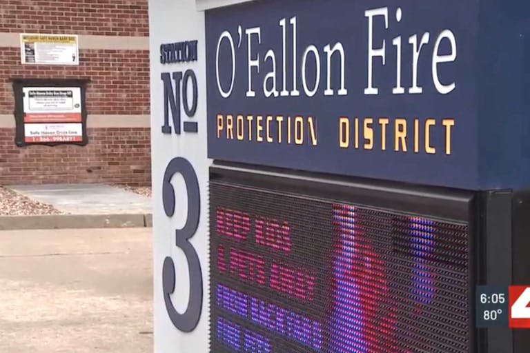 Screenshot: KMOV screenshot of safe haven baby box next to O'Fallon Fire Protection District sign