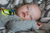 Close-Up Of Baby With Down Syndrome Sleeping On Bed