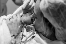 Mother holding her newborn baby child after labor in a hospital. Mother giving birth to a baby boy. Parent and infant first moments of bonding. Buenos Aires. Argentina