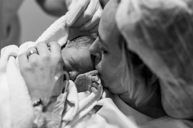 Mother holding her newborn baby child after labor in a hospital. Mother giving birth to a baby boy. Parent and infant first moments of bonding. Buenos Aires. Argentina
