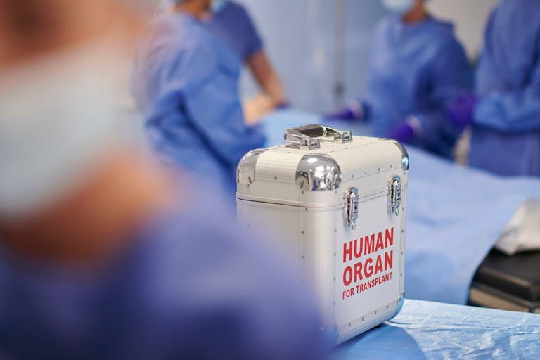 Stock Photo shows a silver briefcase labeled "human organ for transplant" in a medical operating theatre.