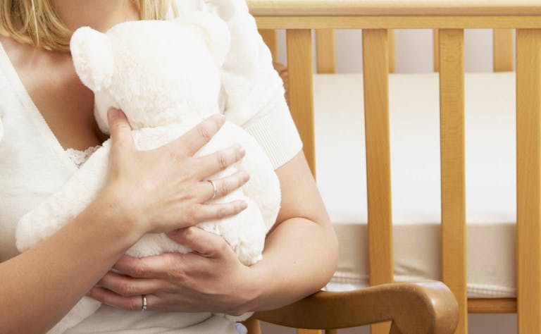 Sad Mother Sitting In Empty Nursery