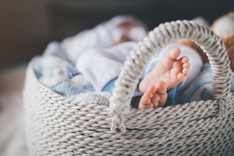 Photo: Marko Pekic/Getty Images Newborn baby boy laying in basket