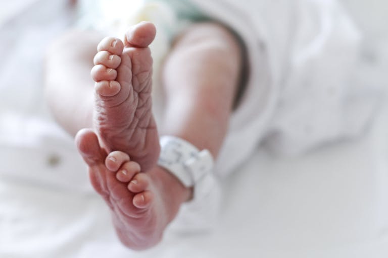 Photo: Isabel Pavia/Getty Images Newborn baby boy at hospital with identity tag on feet, close up