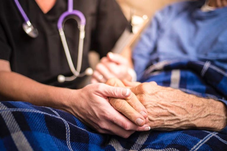 Photo: LPETTET/Getty Images A stock photo of a Hospice Nurse visiting an Elderly male patient who is receiving hospice/palliative care.