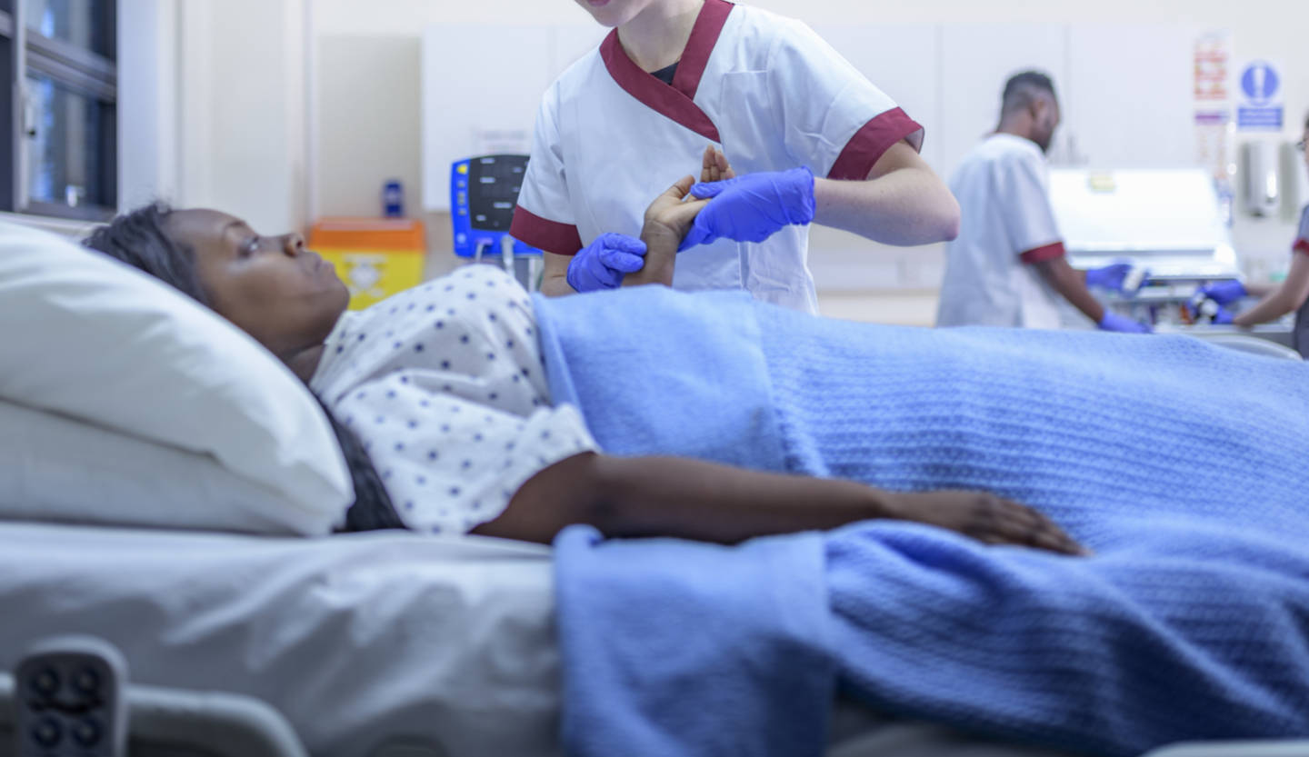 Nurse with patient in hospital ward