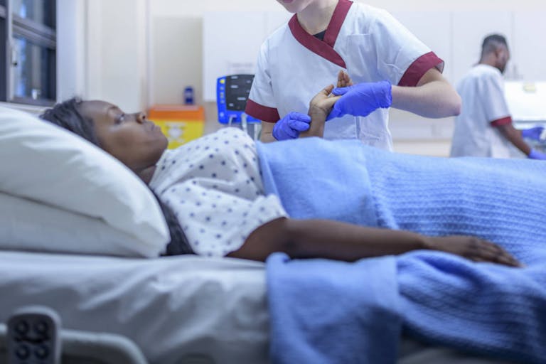 Photo: Monty Rakusen/Getty Images Nurse with patient in hospital ward