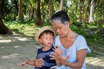 Grandmother bonds with grandson on the beach in the Philippines