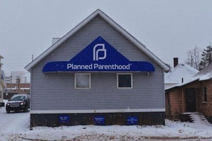 Planned Parenthood facility in Marquette, Michigan. Blue gray building with snow on the roof.