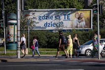 Photo by WOJTEK RADWANSKI/AFP via Getty Images Pedestrians cross a street near a billboard with a poster with the lettering reading 'Where are these children?' in Warsaw, on August 5, 2022. - The billboards, put up in recent weeks by a Catholic foundation, are hard to miss: large and plastered all over Poland, they show two little blonde girls in immaculate white posing in a wheat field -- along with the alarmist caption, "Where are these children?" Falling birth rate statistics displayed alongside in the form of a pictogram claim that the average Polish family had five children in the 1950s, down to three in the 80s and 1.5 today.