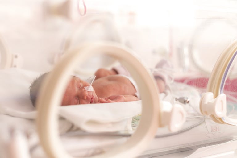 Photo (preemie, 33 weeks): Ondrooo/Getty Images Premature newborn  baby girl in the hospital incubator after c-section in 33 weeks