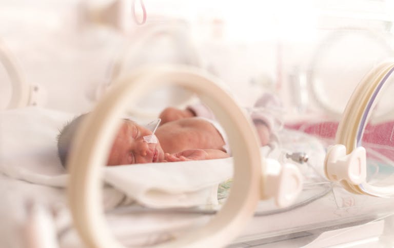Premature newborn  baby girl in the hospital incubator after c-section in 33 weeks