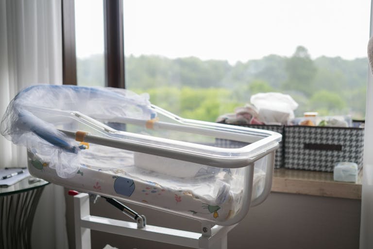 Photo: WePro/Getty Images Empty crib by the window, stroller - stock photo