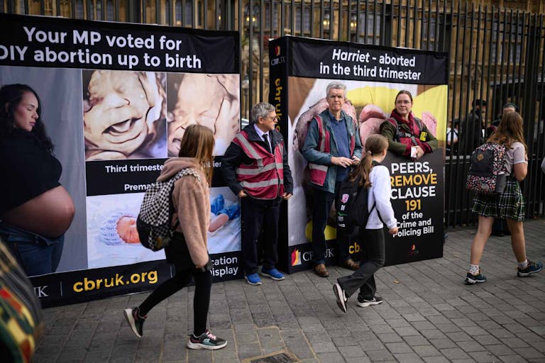 Photo: Leon Neal/Getty Images LONDON, ENGLAND - OCTOBER 16: (EDITOR'S NOTE: Image depicts graphic content) Protestors attempt to cover images of an aborted foetus as young school children pass by, during an anti-abortion protest outside the Houses of Parliament on October 16, 2025 in London, England. The protest, organised by the Centre for Bio-Ethical Reform UK, was meant to coincide with a second reading in the House of Lords of the Crime and Policing Bill, which contains a provision that would end the threat of criminal prosecution for women who terminate their pregnancies at any point during gestation.
