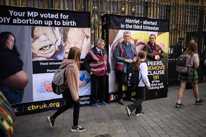 LONDON, ENGLAND - OCTOBER 16: (EDITOR'S NOTE: Image depicts graphic content) Protestors attempt to cover images of an aborted foetus as young school children pass by, during an anti-abortion protest outside the Houses of Parliament on October 16, 2025 in London, England. The protest, organised by the Centre for Bio-Ethical Reform UK, was meant to coincide with a second reading in the House of Lords of the Crime and Policing Bill, which contains a provision that would end the threat of criminal prosecution for women who terminate their pregnancies at any point during gestation.