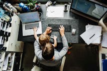 Photo: Franziska & Tom Werner/Getty Images An aerial view of a mother working on a laptop in her office at home with her young daughter sitting on her lap.