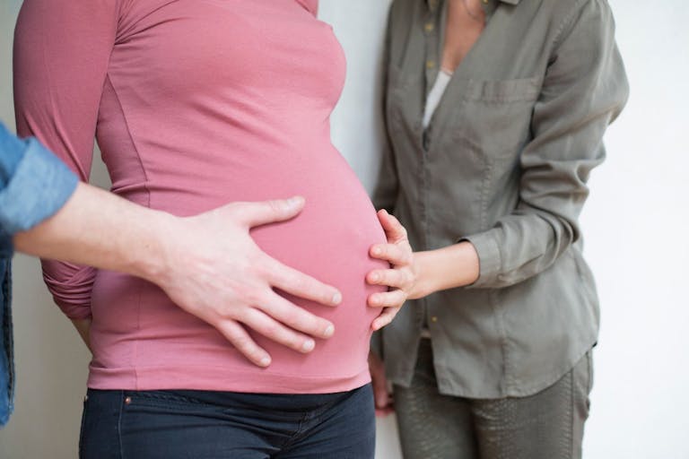 Photo: Sandy AKNINE/Getty Images Closeup of a human hand and a woman on the belly of a pregnant woman 6 months - stock photo