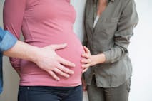 Closeup of a human hand and a woman on the belly of a pregnant woman 6 months - stock photo