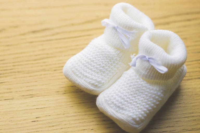 Photo: Manuel Breva Colmeiro/Getty Images Photograph of some beautiful white bootees on a wooden table