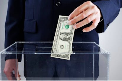 A male hand voting with money. Bribe - stock photo