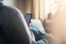 Photo: Johner Images/Getty Images Man taking assistance of AI through smart phone at home