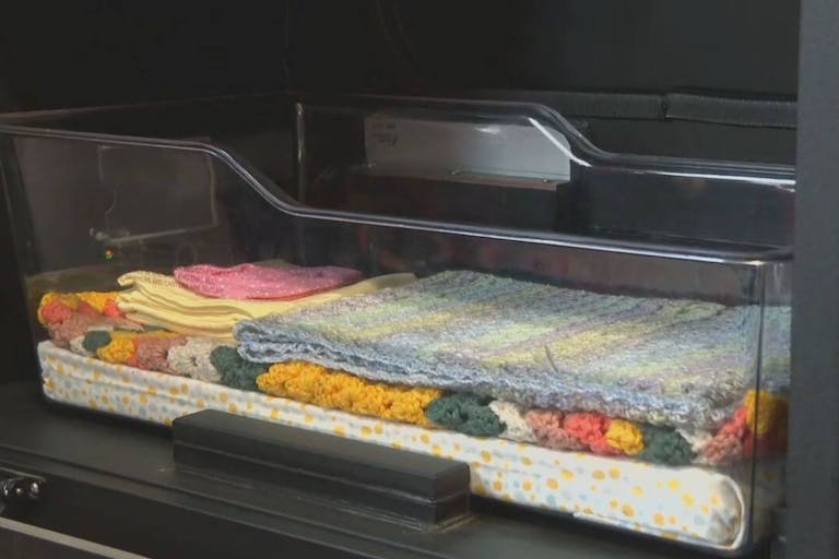 A clear cradle with mattress acts as the baby box.