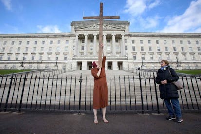An anti-abortion activist poses for a photograph whilst demonstrating outside of Parliament Buildings, the seat of the Northern Ireland Assembly, on the Stormont Estate in Belfast, Northern Ireland, on October 21, 2019, as a number of lawmakers returned to attend a special sitting. - A group of Northern Irish lawmakers returned to their parliament on Monday in a last-minute protest at the liberalisation of abortion laws, set to come into force after being decided by London for the suspended Belfast executive. The regional government in Belfast collapsed in January 2017 after a scandal over a renewable heating scheme split the power-sharing executive, amid a breakdown in trust. Abortion is currently illegal in the province, except when the mother's life is in danger.