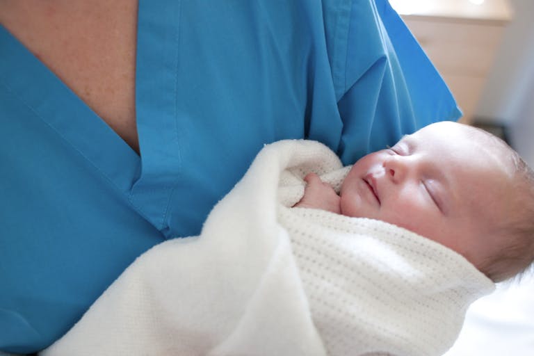Photo: IAN HOOTON/Getty Images/Science Photo Library Newborn baby held by a nurse.