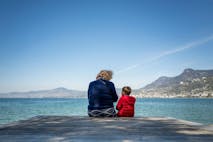Photo: Fabrice Coffrini/AFP via Getty Images An elderly woman speaks with a young boy under a clear sky, on the edge of Lake Geneva in Villeneuve, western Switzerland, on April 8, 2025.
