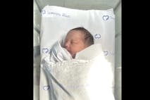 Screenshot: The Daily Mail newborn baby girl abandoned in toilet tank in Bangkok, Thailand, lays in bassinet