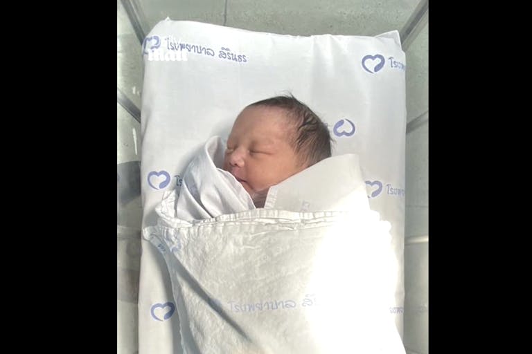 Screenshot: The Daily Mail newborn baby girl abandoned in toilet tank in Bangkok, Thailand, lays in bassinet