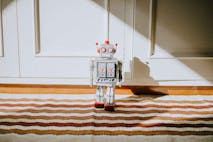 toy robot surrounded by other toys on the carpet in child bedroom