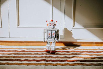 toy robot surrounded by other toys on the carpet in child bedroom