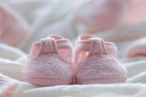 Photo: Alicia Llop/Getty Images Small pink shoes on a white blanket