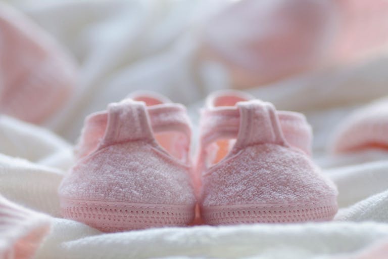 Photo: Alicia Llop/Getty Images Small pink shoes on a white blanket