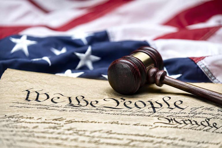 Photo: Joe Belanger/Getty Images American flag draped around a judge's gavel block and the United States Constitution for use as a symbol of laws, freedom and separation of government powers.