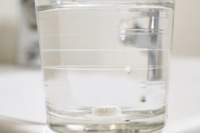 Photo: Aitor Diago/Getty Images Glass of water with a pill inside it.