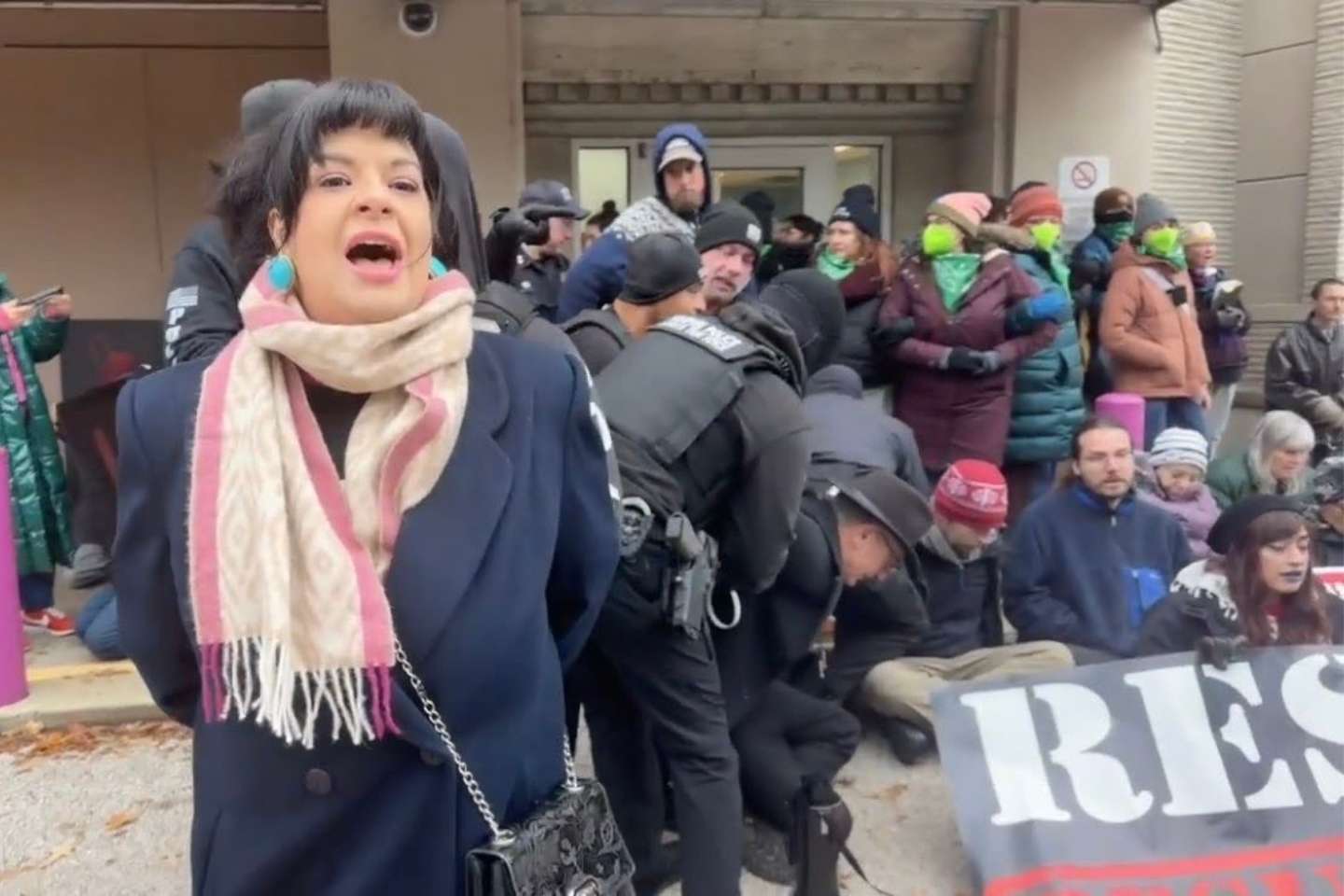 The image shows Terissa Bukovinac, founder of Progressive Anti-Abortion Uprising, being arrested outside of Planned Parenthood in Memphis with several other activists behind her.