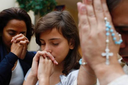 Family praying at home - stock photo